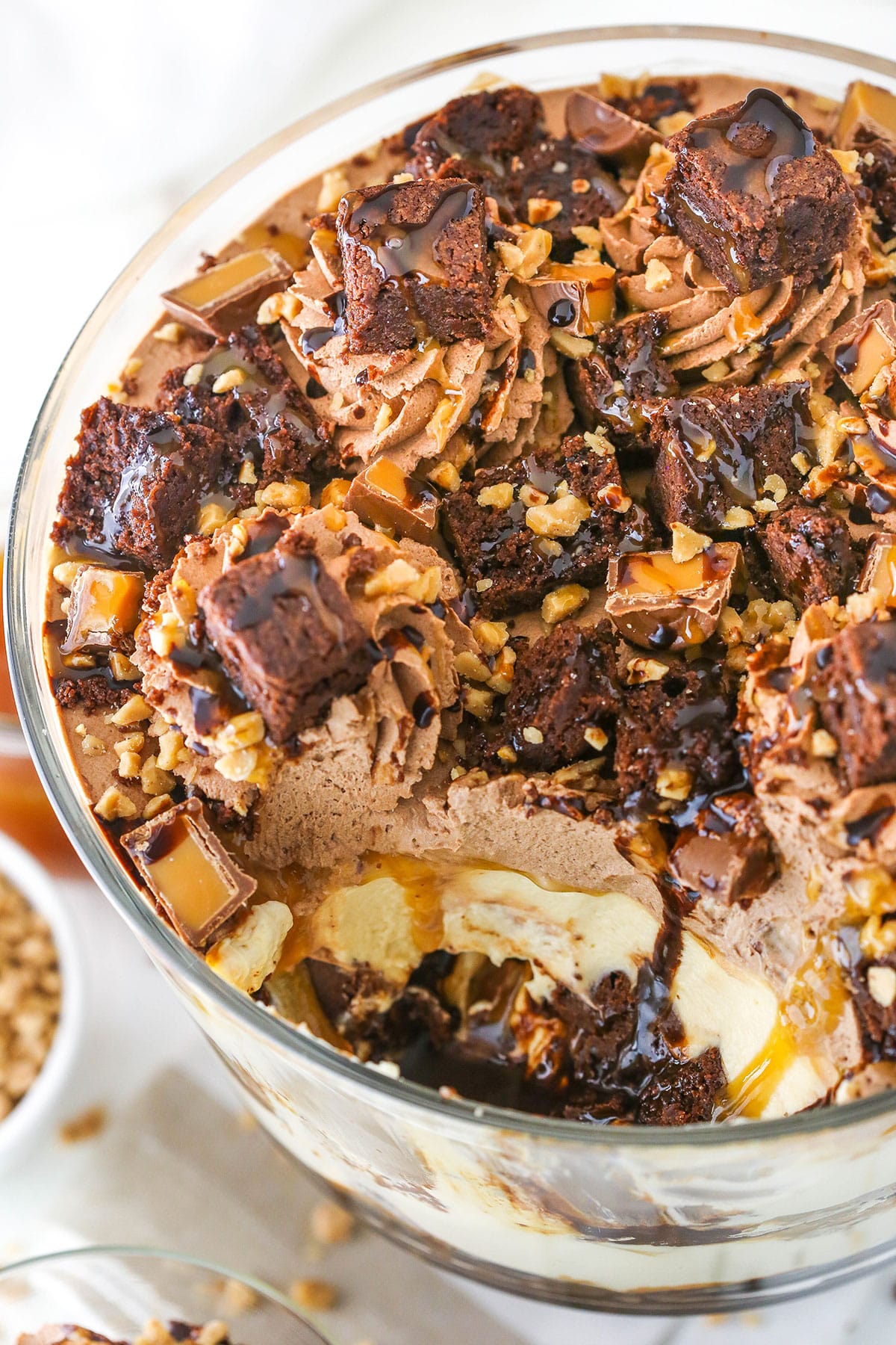 Overhead view of Caramel Cheesecake Brownie Trifle in a clear glass cake stand