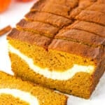 Side view of Cheesecake Swirl Pumpkin Bread sliced with the front slice removed