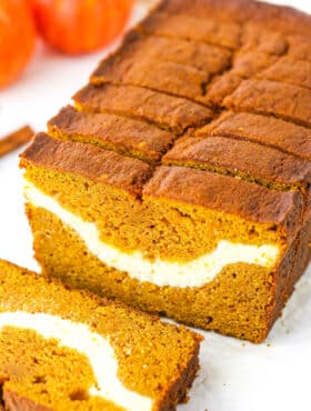 Side view of Cheesecake Swirl Pumpkin Bread sliced with the front slice removed