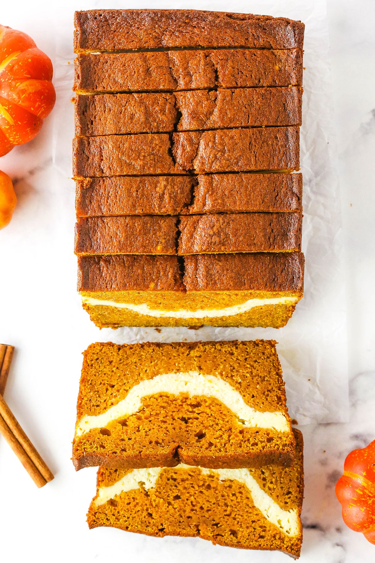 Overhead view of Cheesecake Swirl Pumpkin Bread sliced with the front two slices facing up