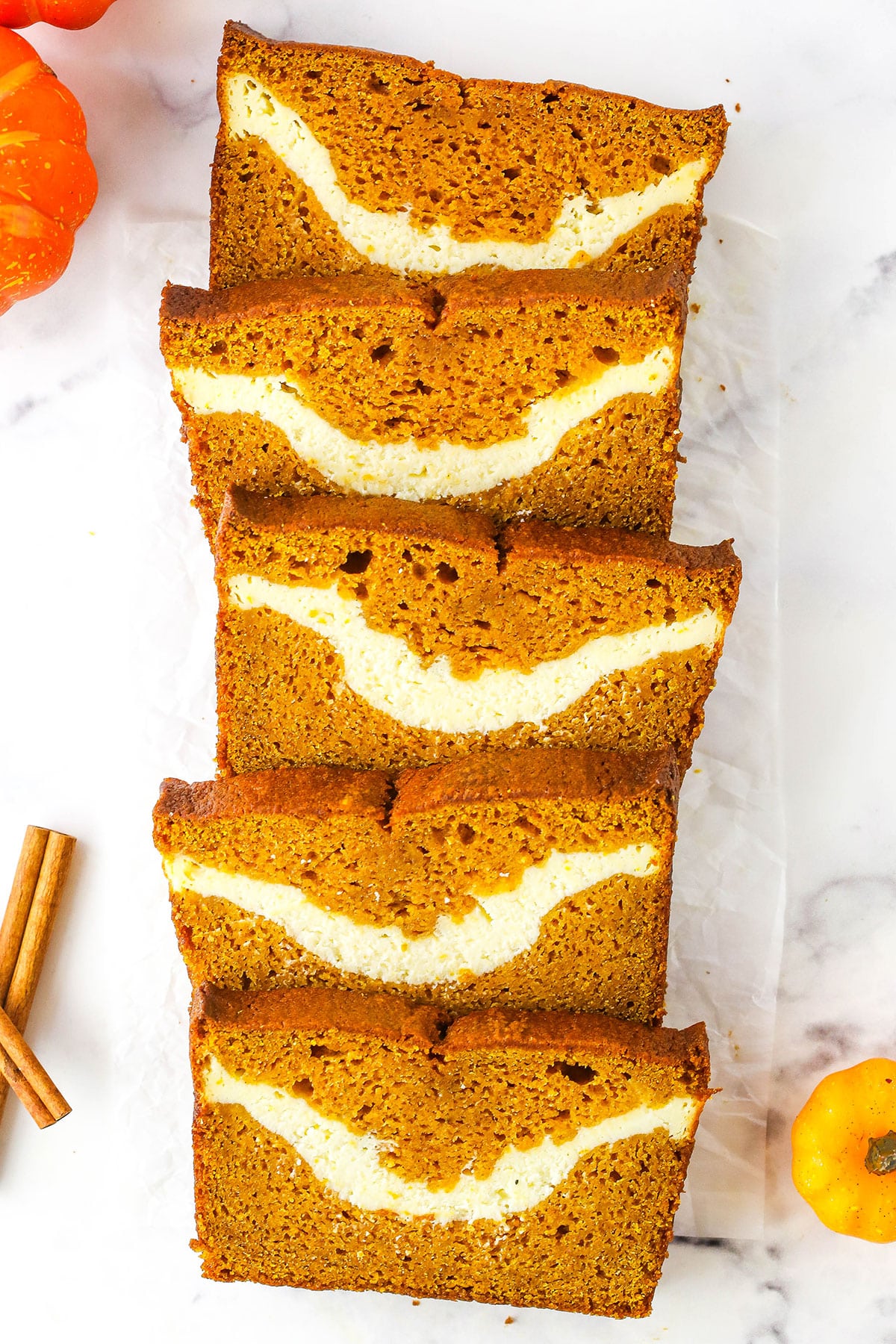 Overhead view of five slices of Cheesecake Swirl Pumpkin Bread layered and facing up