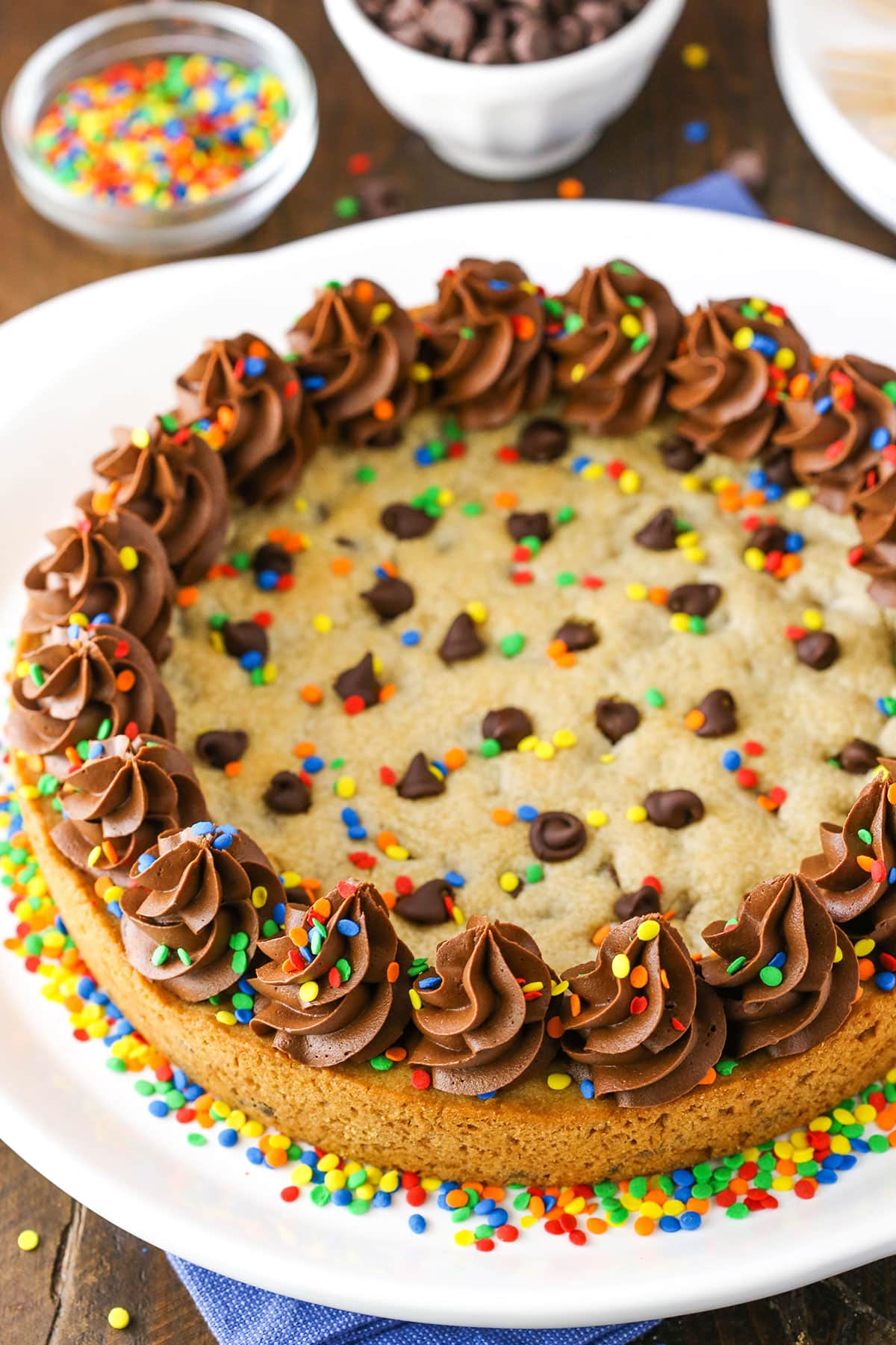 A full Chocolate Chip Cookie Cake with multicolored sprinkles on a white plate