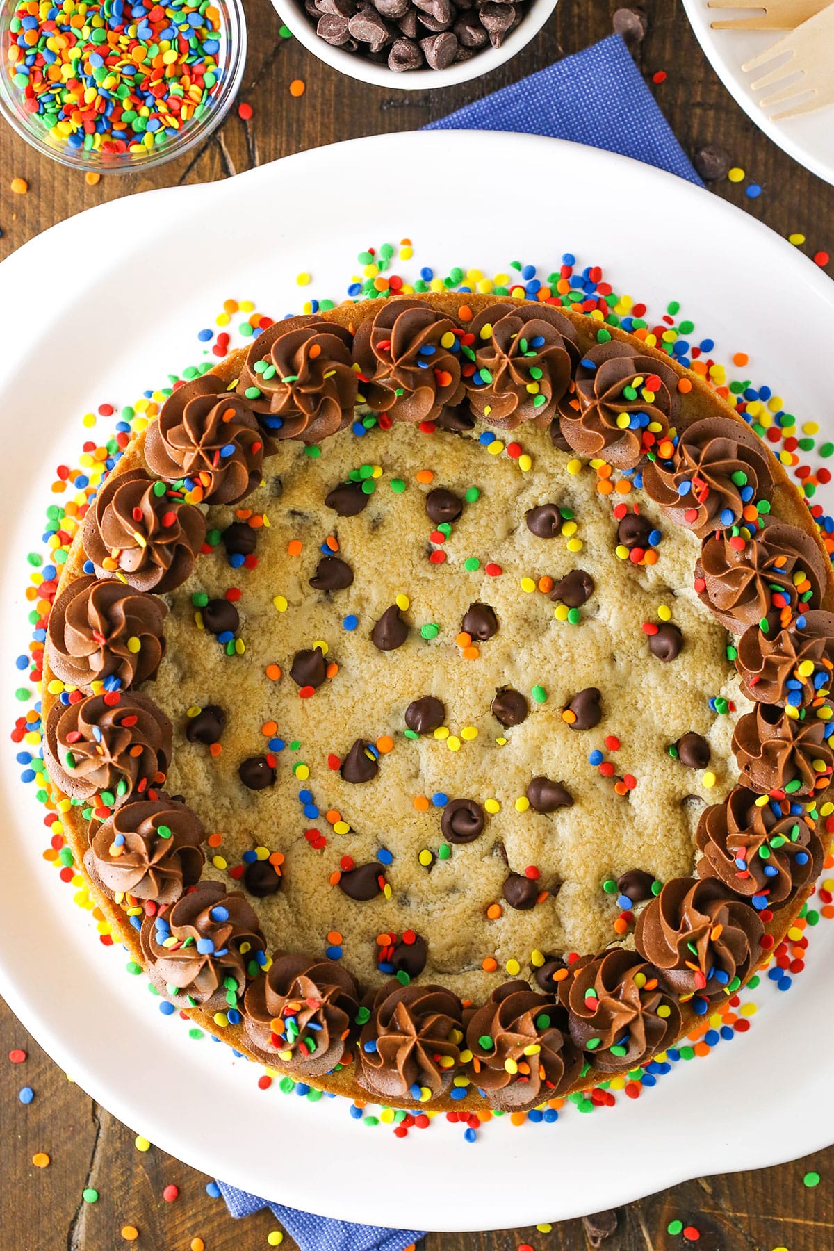 A full Chocolate Chip Cookie Cake with multicolored sprinkles on a white plate