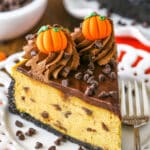 A slice of Chocolate Chip Pumpkin Cheesecake next to a silver fork on a white plate