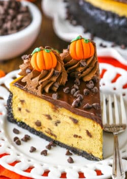 A slice of Chocolate Chip Pumpkin Cheesecake next to a silver fork on a white plate