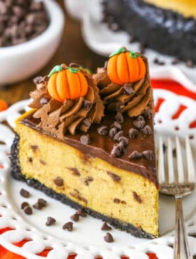 A slice of Chocolate Chip Pumpkin Cheesecake next to a silver fork on a white plate