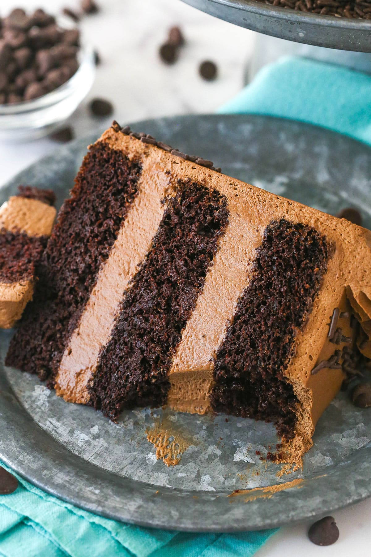 A slice of chocolate mousse cake on a plate with a bite taken out of it.