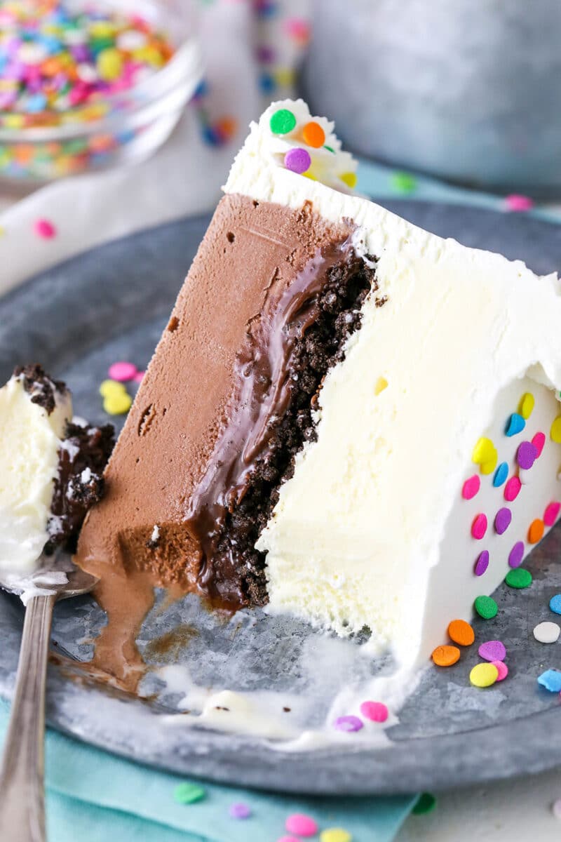 A slice of Copycat Dairy Queen Ice Cream Cake with a bite taken out on it's side next to a fork on a silver plate