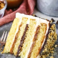 A slice of Drumstick Layer Cake next to a fork on a silver plate