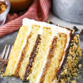 A slice of Drumstick Layer Cake next to a fork on a silver plate