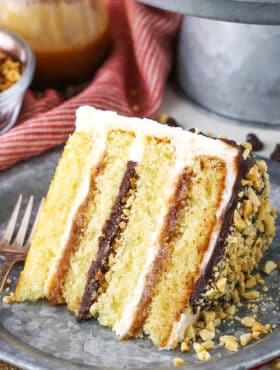 A slice of Drumstick Layer Cake next to a fork on a silver plate