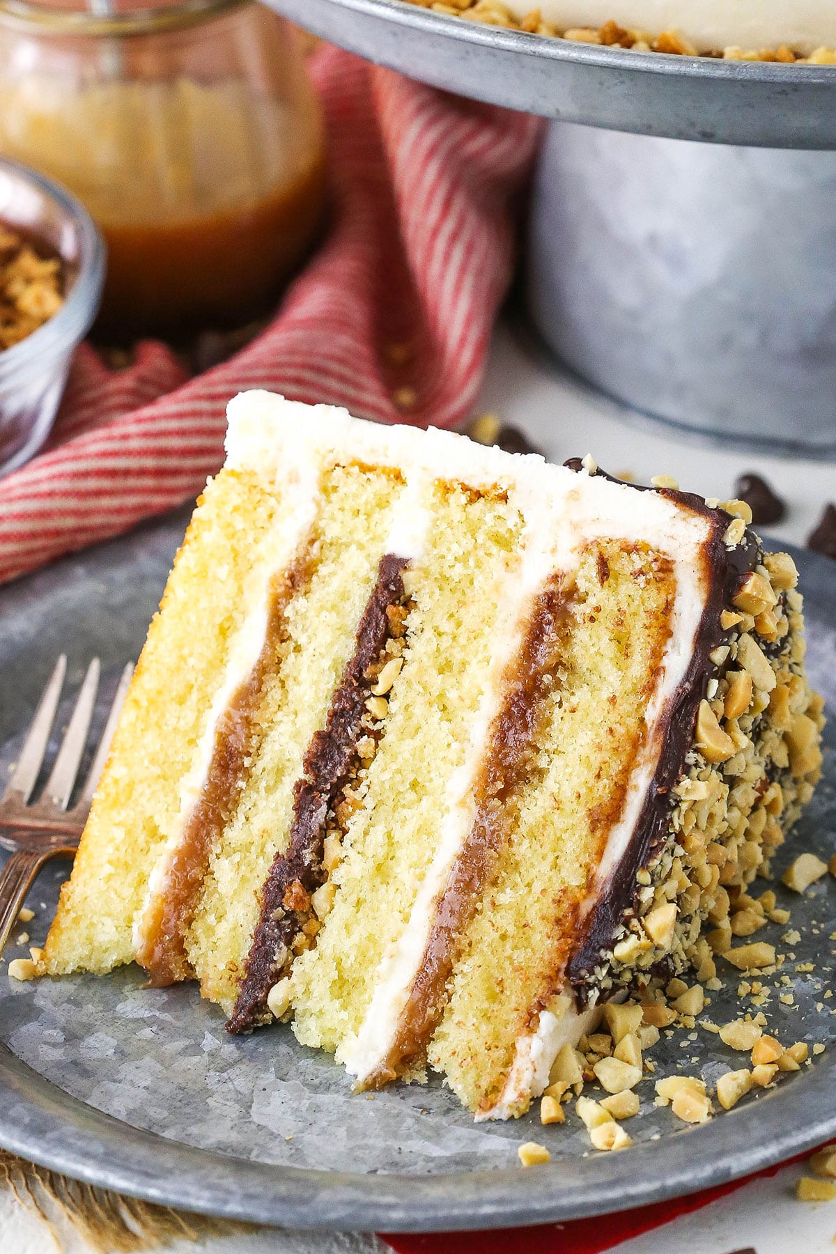 A slice of Drumstick Layer Cake next to a fork on a silver plate