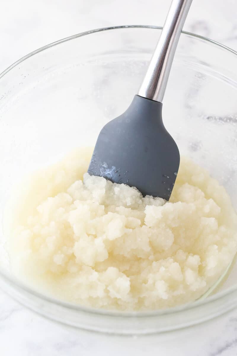 Mixing together oil, sugar, and vanilla extract in a mixing bowl.