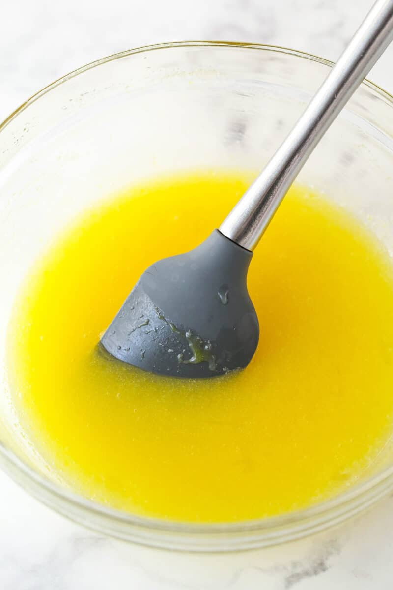 Mixing eggs into wet ingredients for homemade brownies.