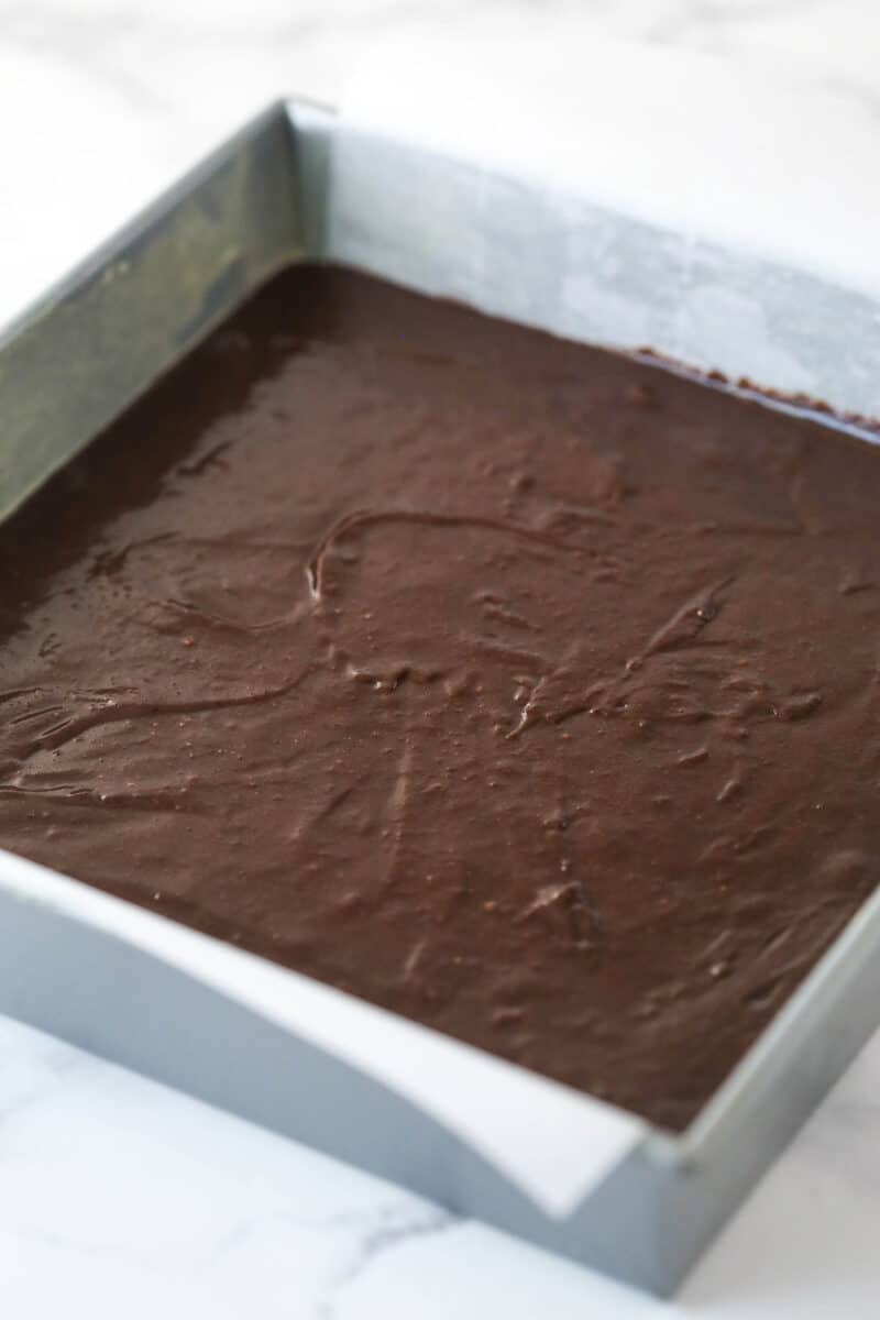 Brownie batter in a baking pan ready to be baked.
