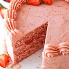 Homemade Strawberry Cake with a slice removed on a white table top