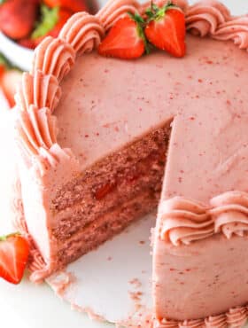 Homemade Strawberry Cake with a slice removed on a white table top