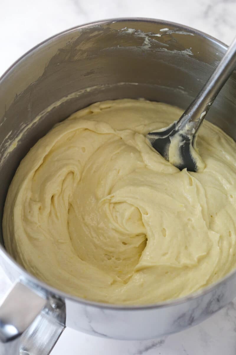 This lemon layer cake is made up of three layers of fluffy lemon cake that are filled and frosted with vibrant lemon cream cheese frosting. Mixing dry ingredients into wet ingredients for cake batter.