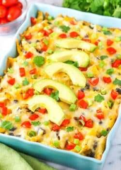 Mexican Chicken Casserole in a blue serving platter topped with slices of avocado