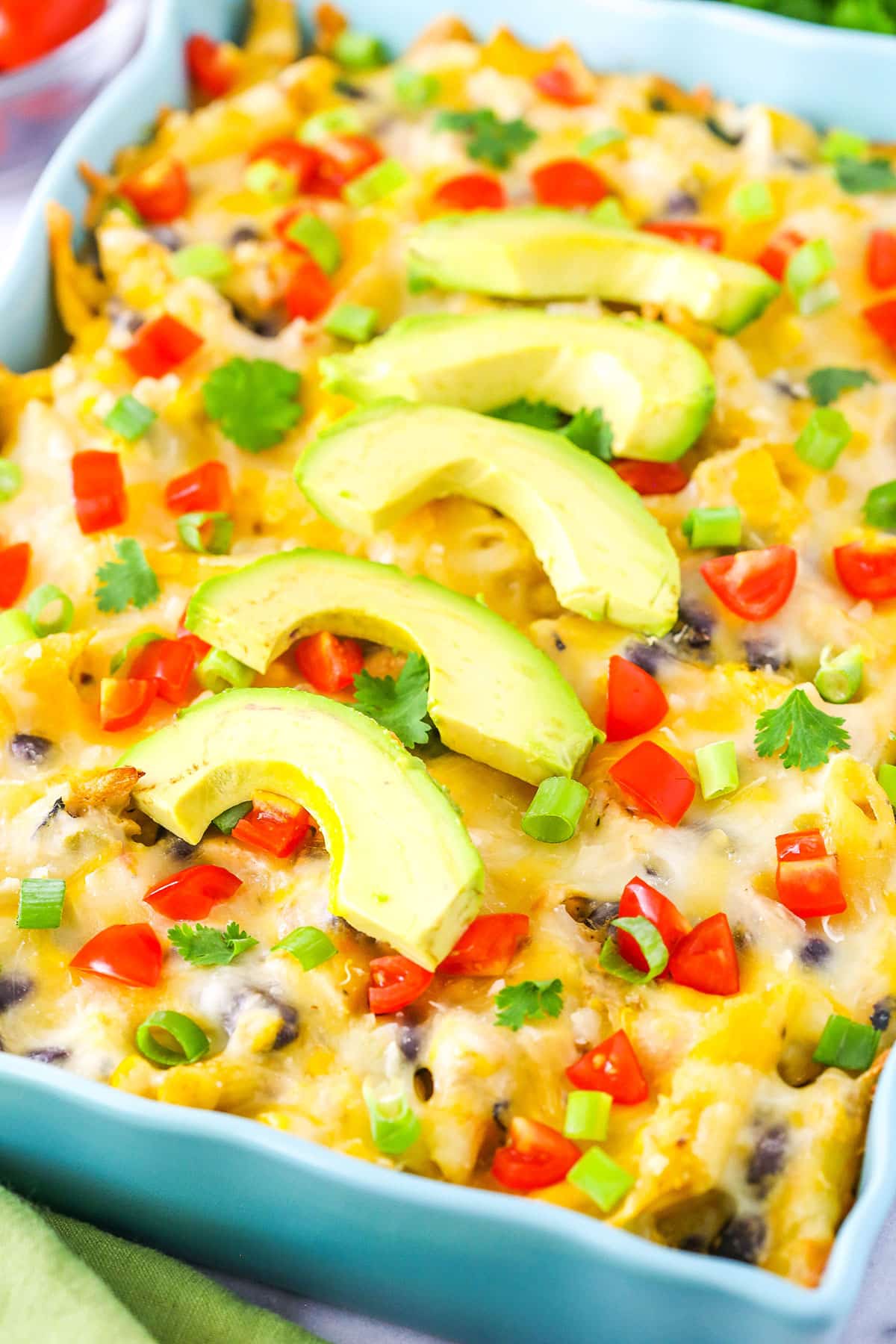 Mexican Chicken Casserole in a blue serving platter topped with slices of avocado