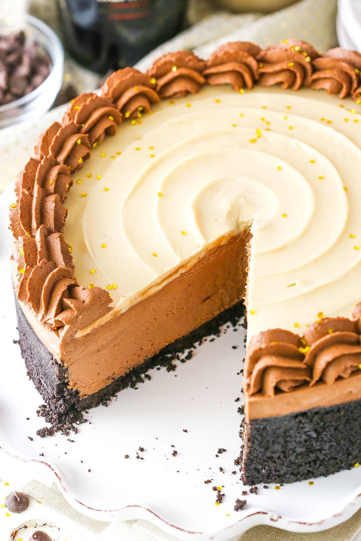 No Bake Baileys Chocolate Cheesecake with a serving removed on a white cake stand