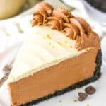 A slice of No Bake Baileys Chocolate Cheesecake next to a fork on a white plate