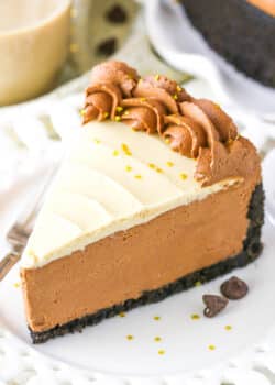 A slice of No Bake Baileys Chocolate Cheesecake next to a fork on a white plate