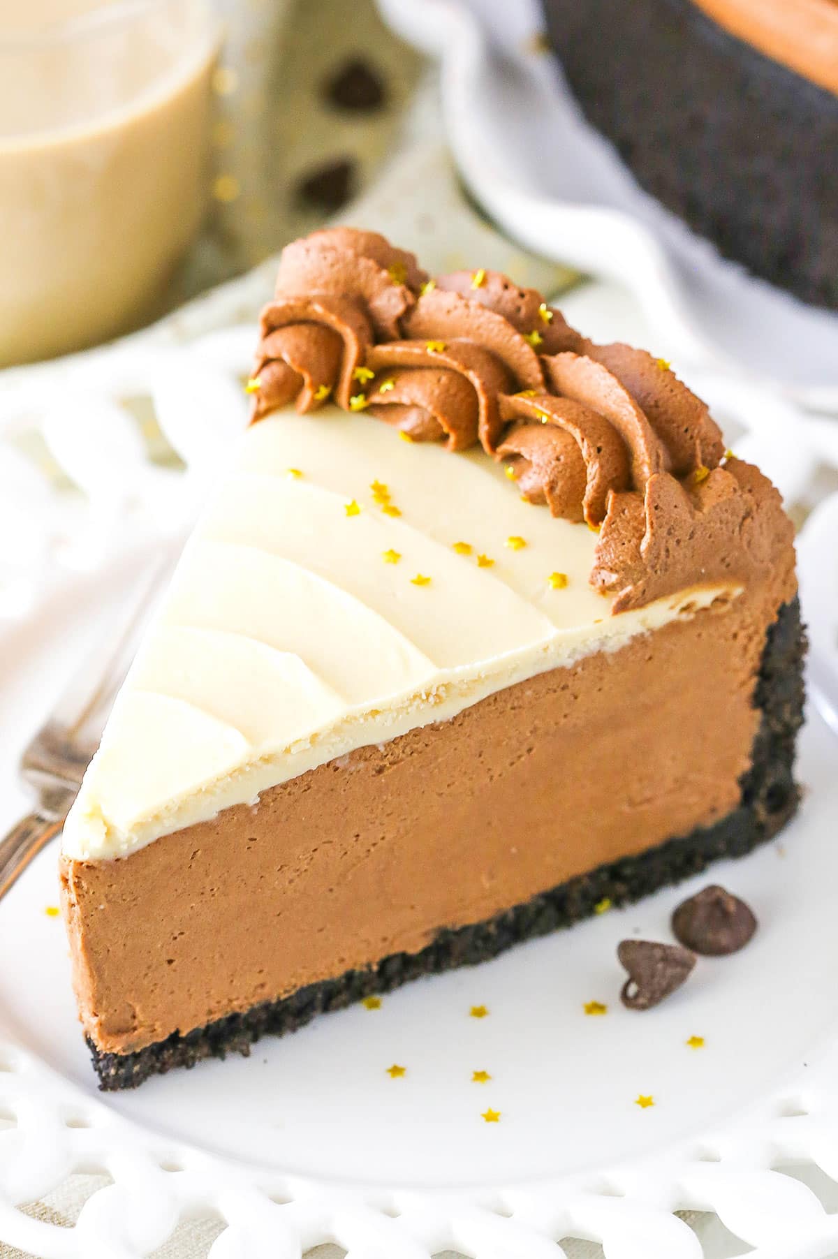 A slice of No Bake Baileys Chocolate Cheesecake next to a fork on a white plate