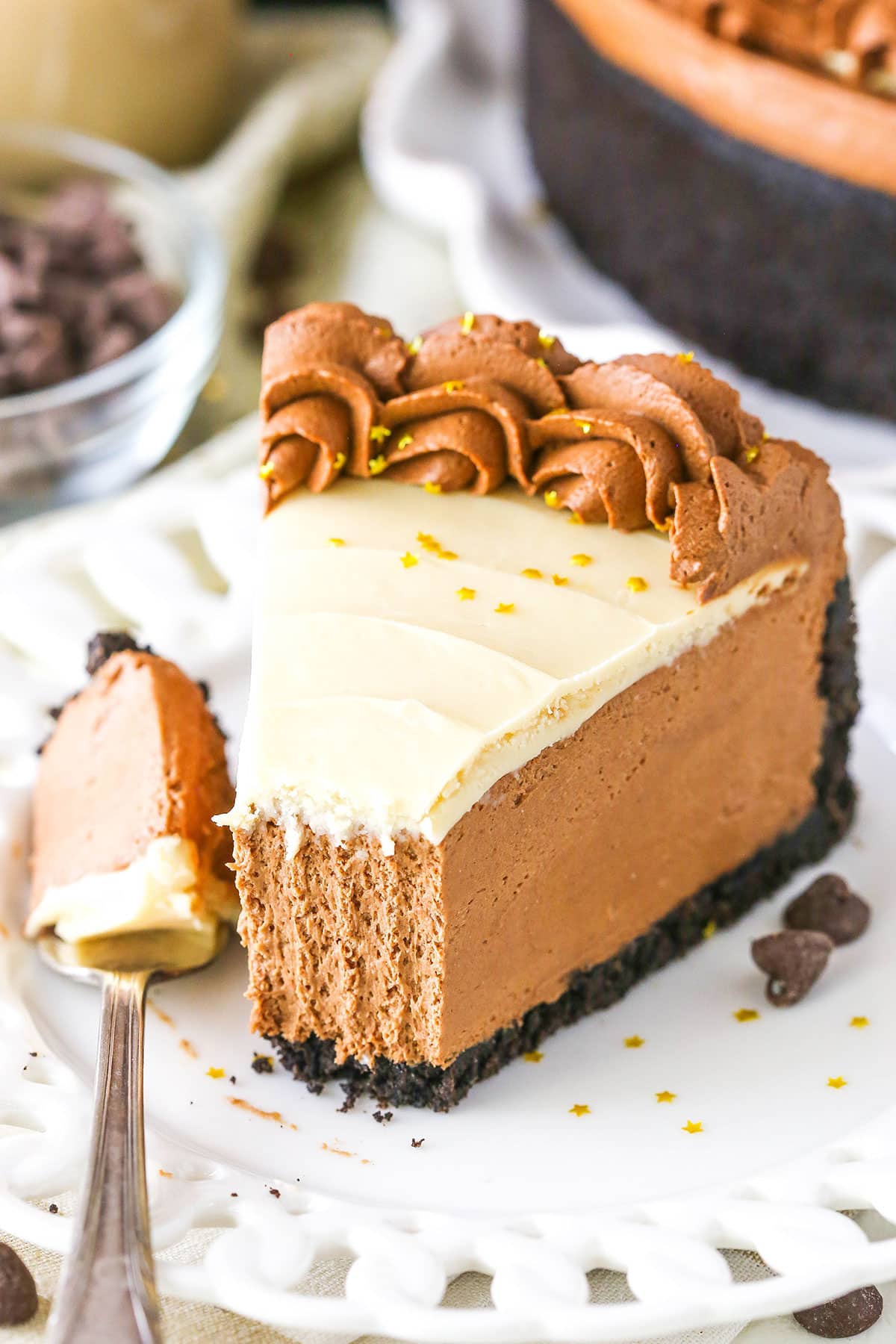 A slice of No Bake Baileys Chocolate Cheesecake with a bite removed next to a fork on a white plate