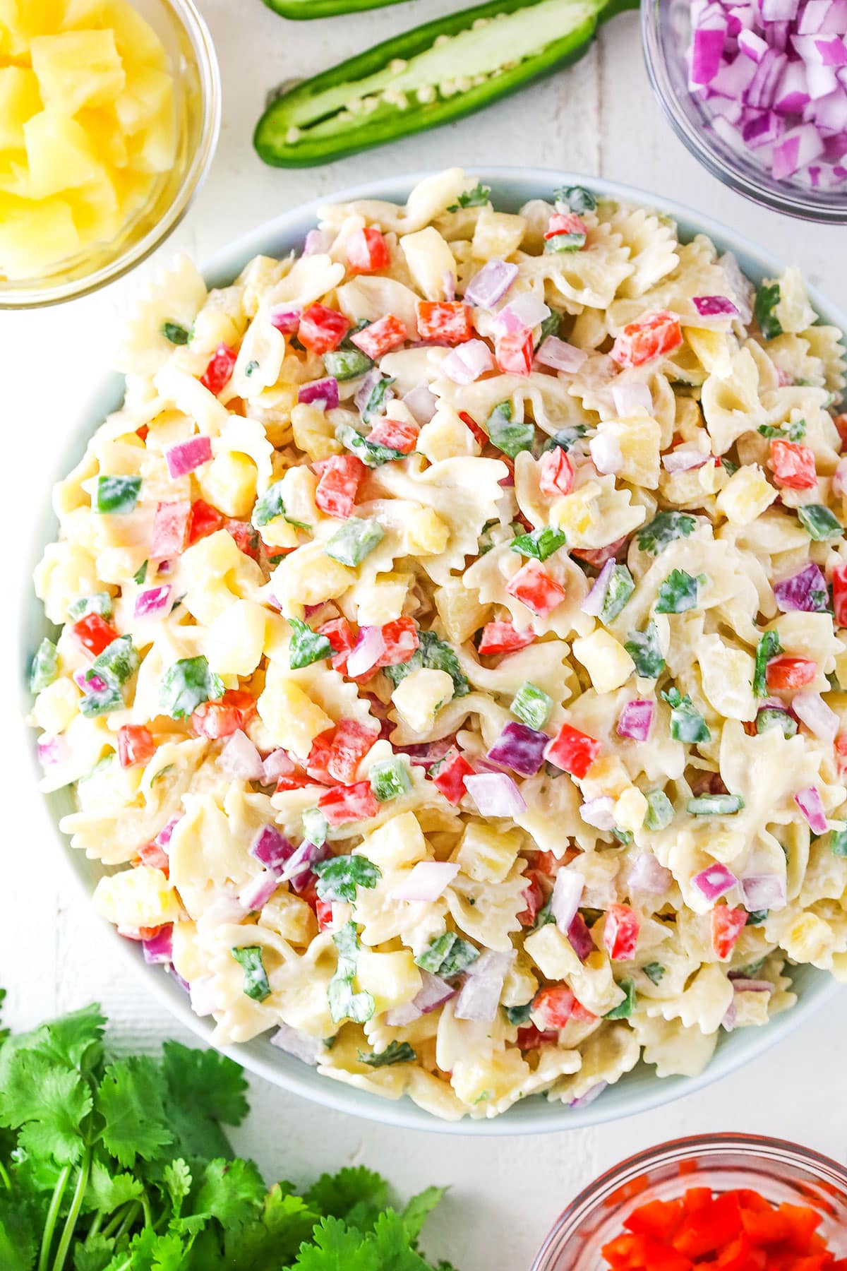 Overhead view of Pineapple Salsa Pasta Salad in a white bowl on a white table