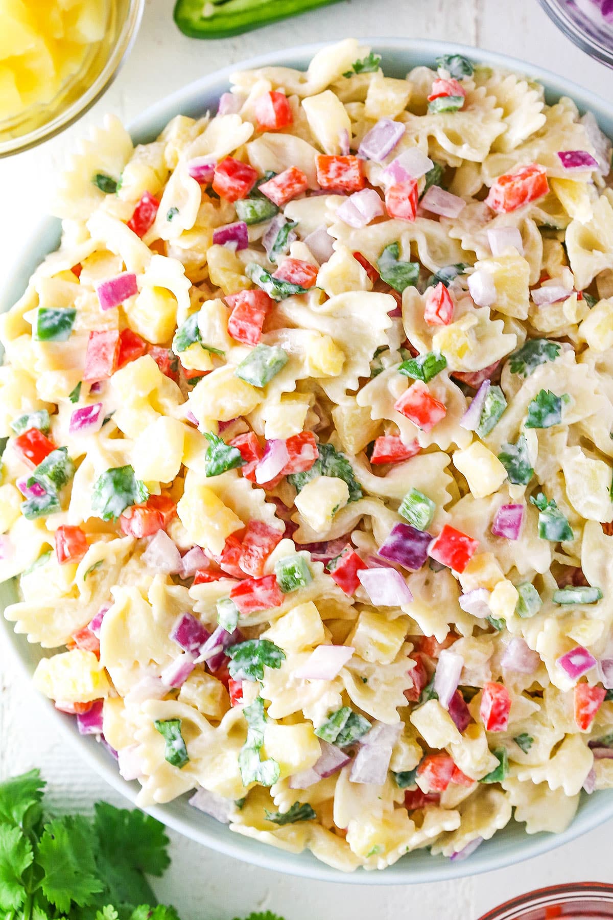 Overhead view of Pineapple Salsa Pasta Salad in a white bowl on a white table