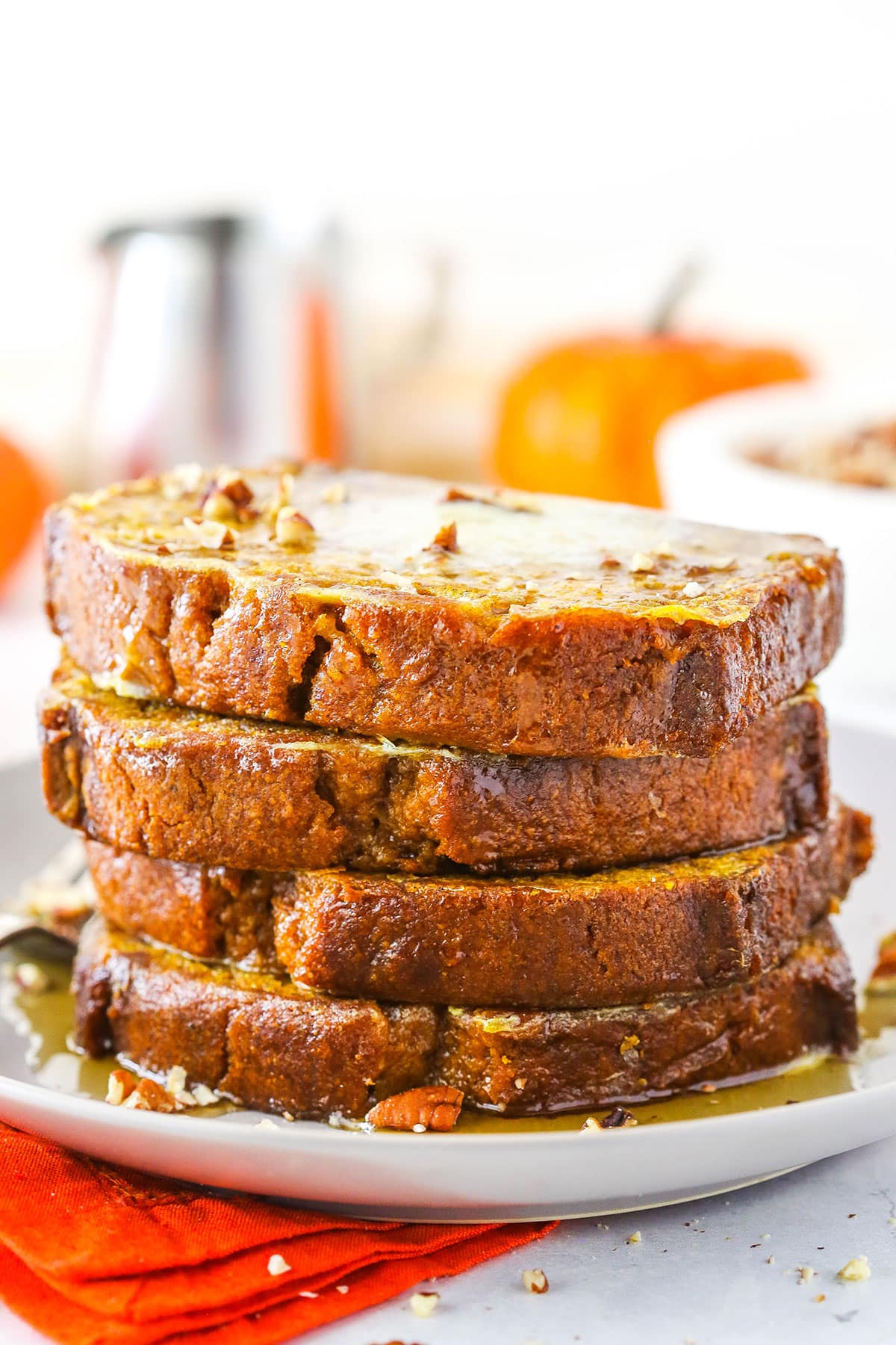 Side view of four slices of Pumpkin Bread French Toast on a white plate