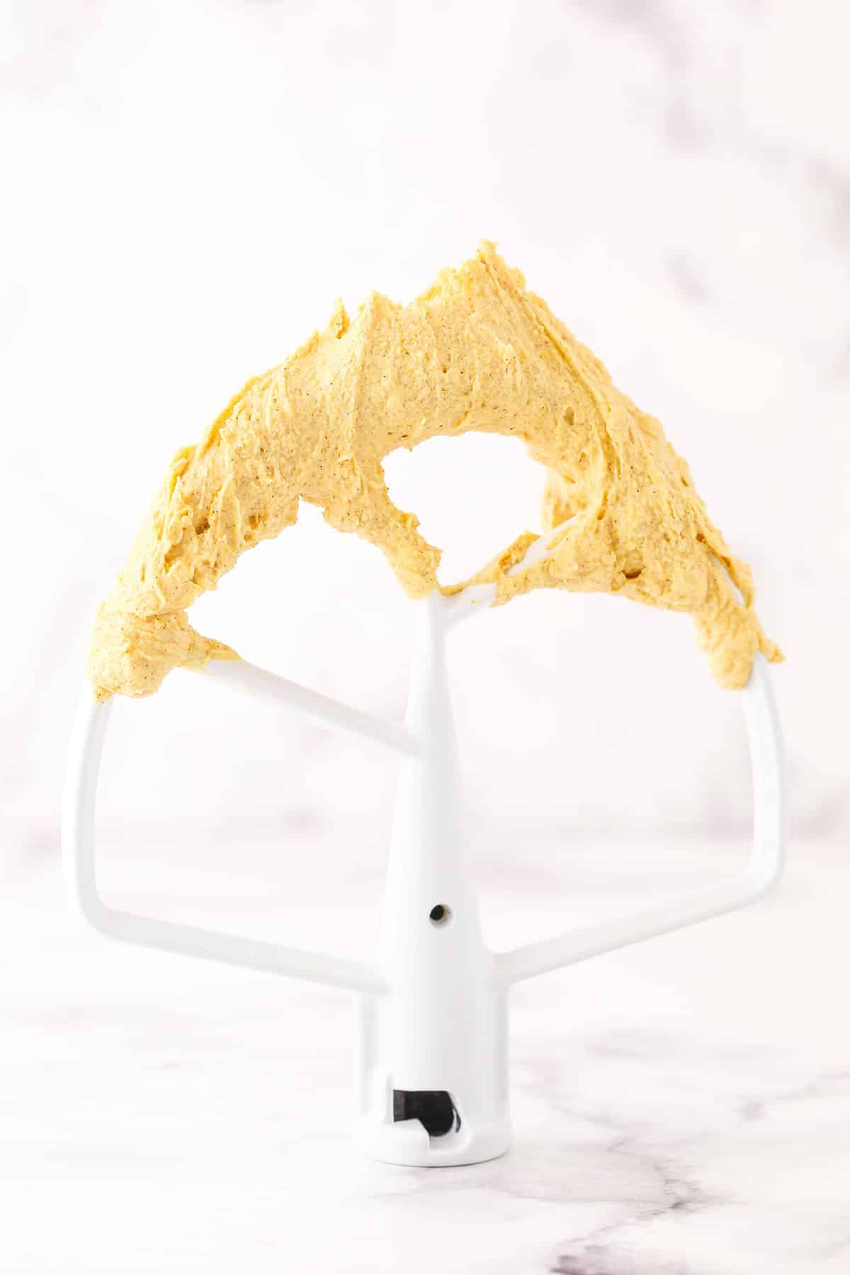 Pumpkin Spice Buttercream Frosting on a mixer beater blade