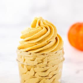 A swirl of Pumpkin Frosting in a clear glass jar