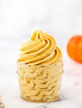 Pumpkin Spice Buttercream Frosting piped into a clear glass jar