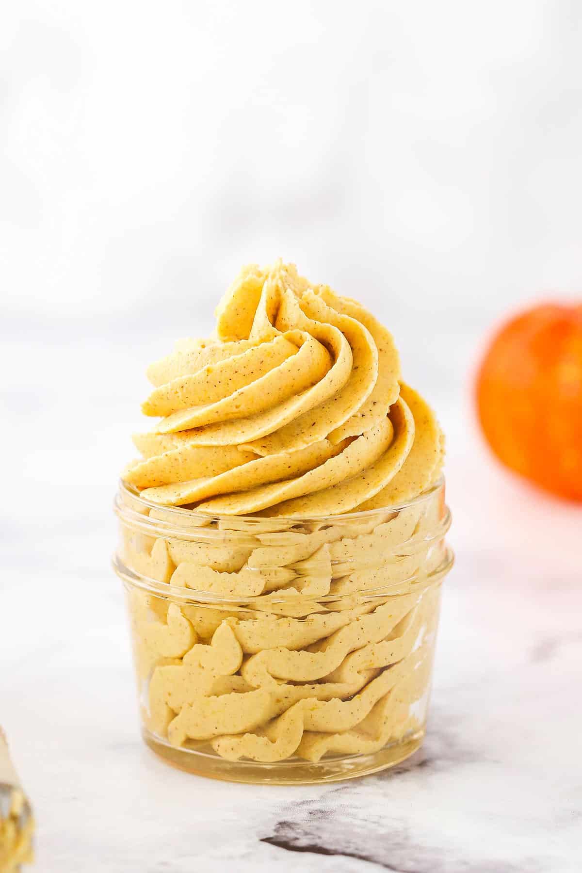 Pumpkin Spice Buttercream Frosting piped into a clear glass jar