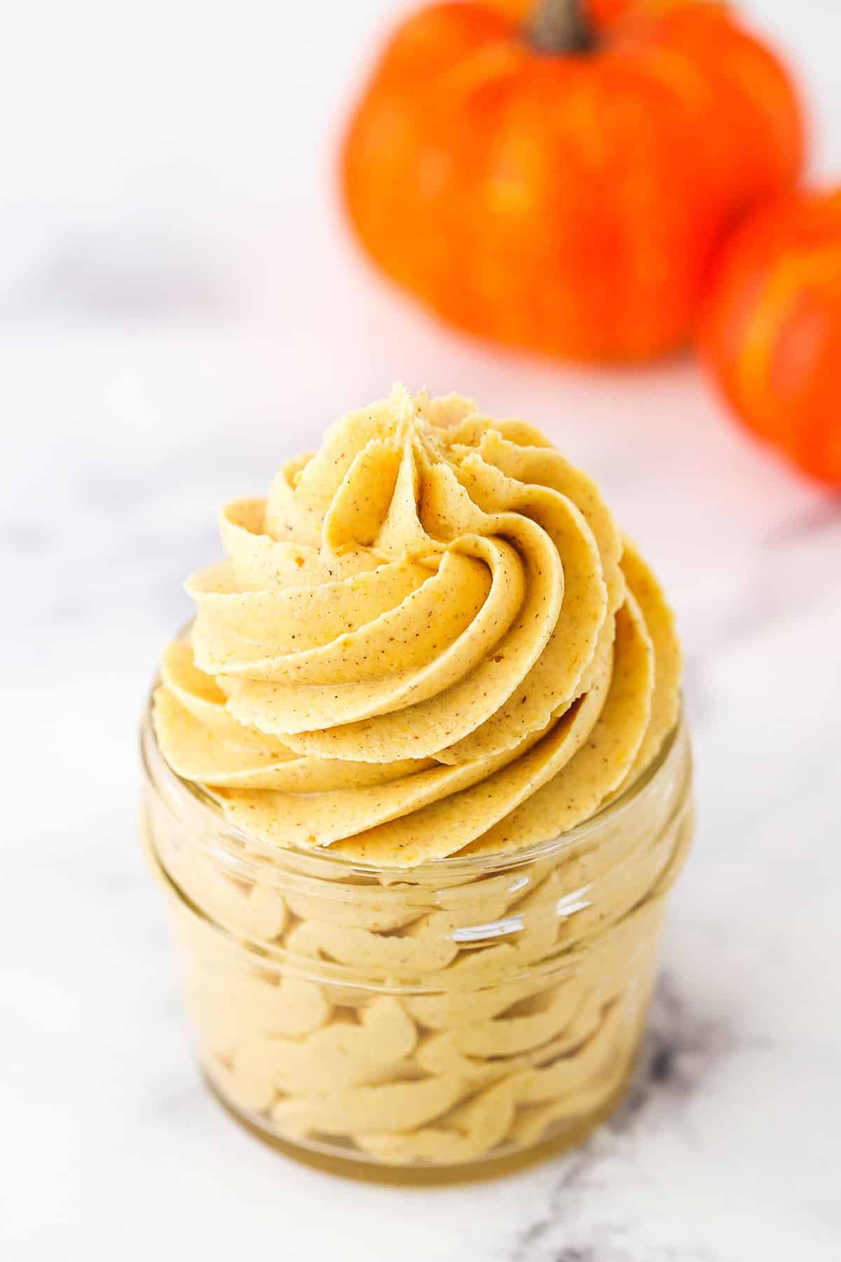Pumpkin Spice Buttercream Frosting piped into a clear glass jar