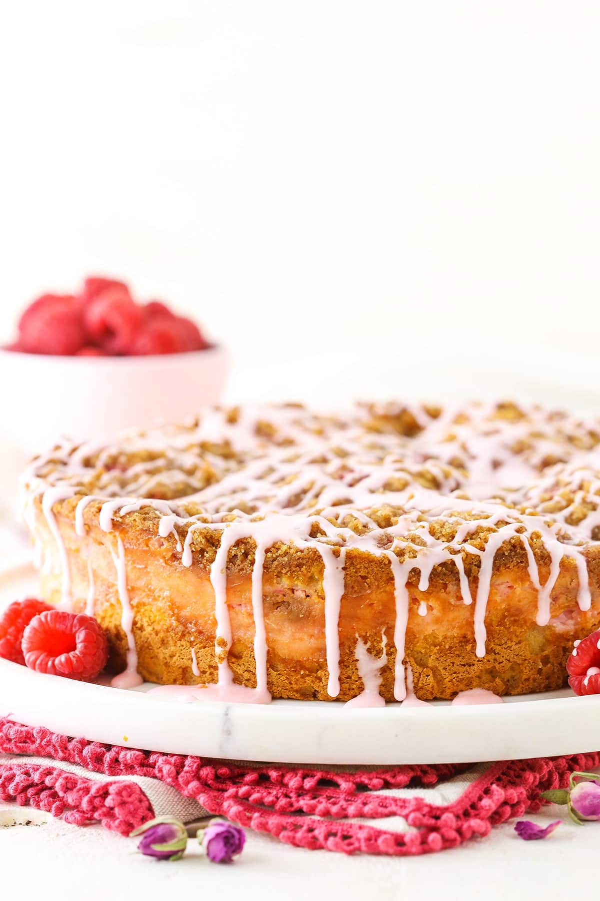 Side view of a Raspberry Rose Coffee Cake on a white serving platter