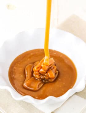 Pouring Salted Caramel Sauce into a white serving dish