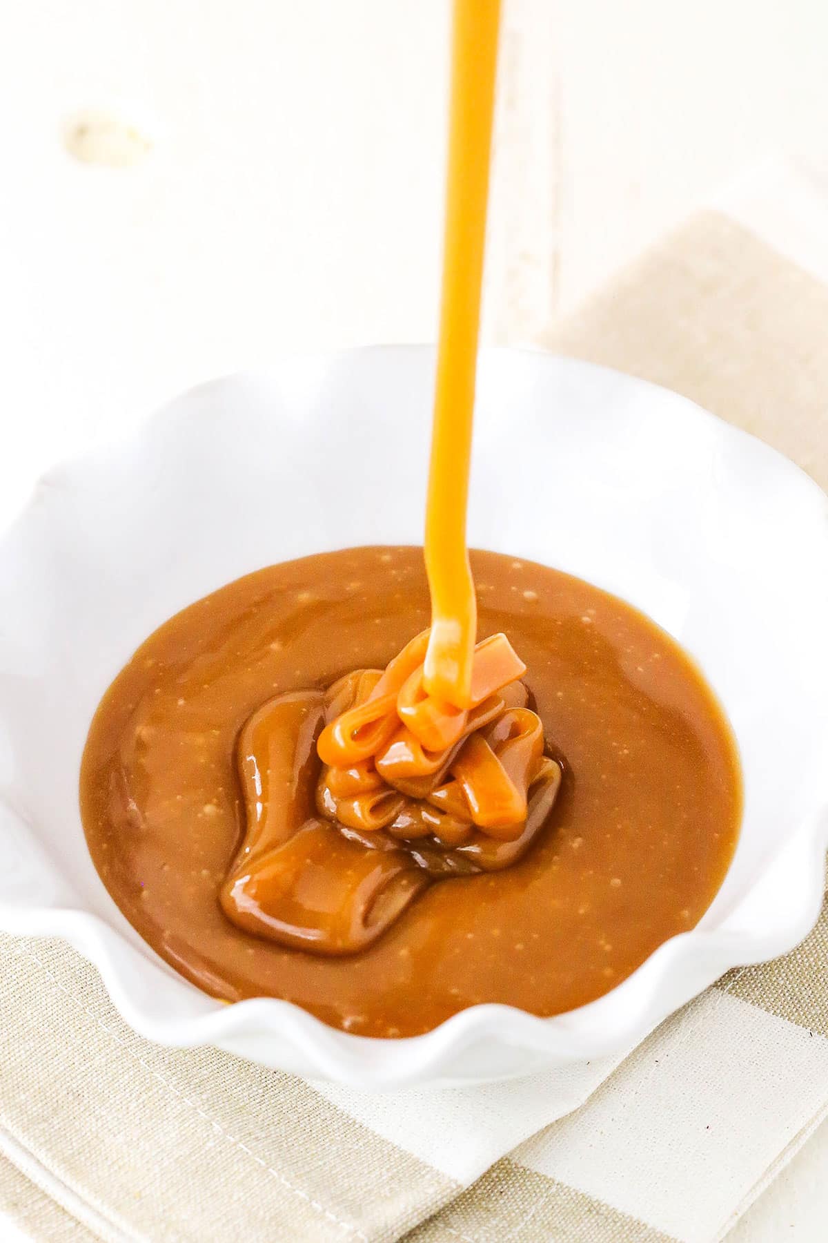 Pouring Salted Caramel Sauce into a white serving dish