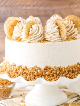 Side view of a full Snickerdoodle Layer Cake on a white cake stand