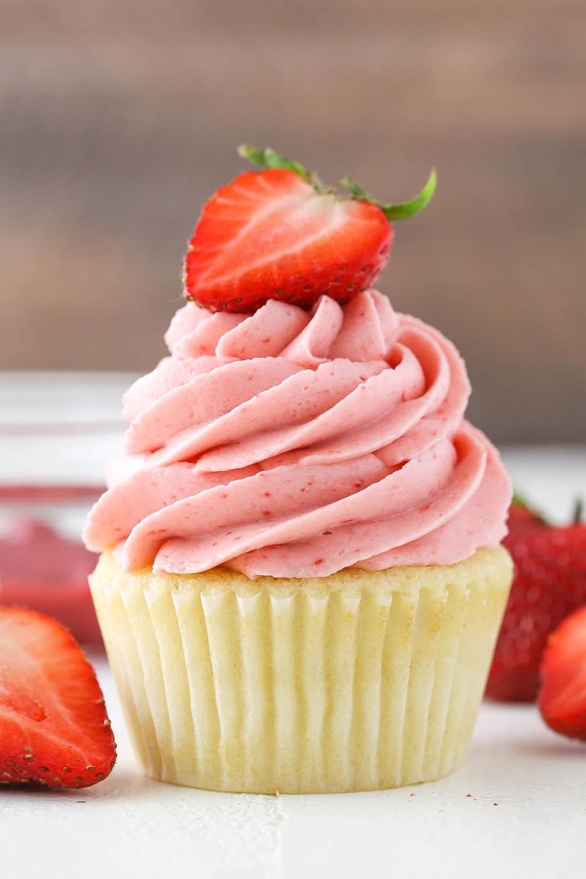 A vanilla cupcake with Homemade Strawberry Frosting piped on top