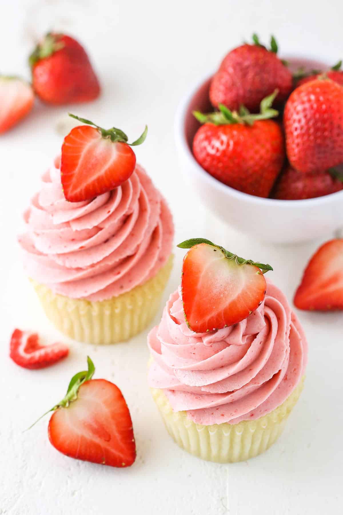 Two vanilla cupcakes with Homemade Strawberry Frosting piped on top