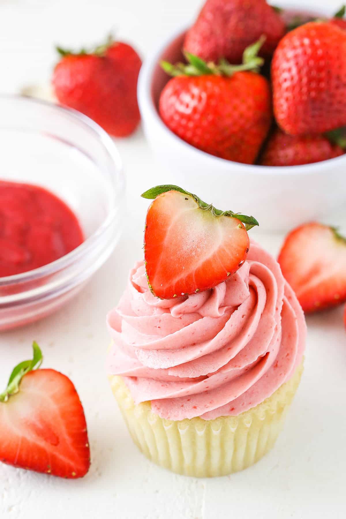 A vanilla cupcake with Homemade Strawberry Frosting piped on top