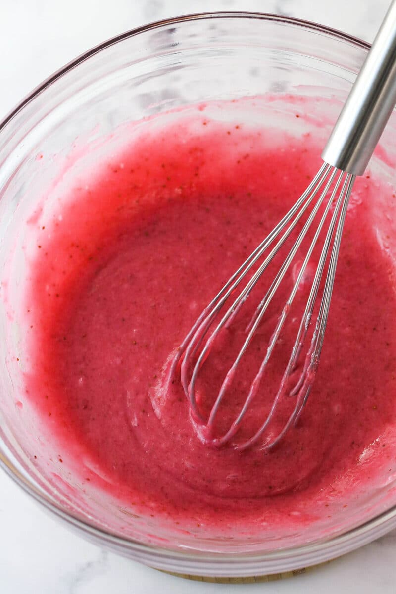 Whisking powdered sugar into strawberry icing.