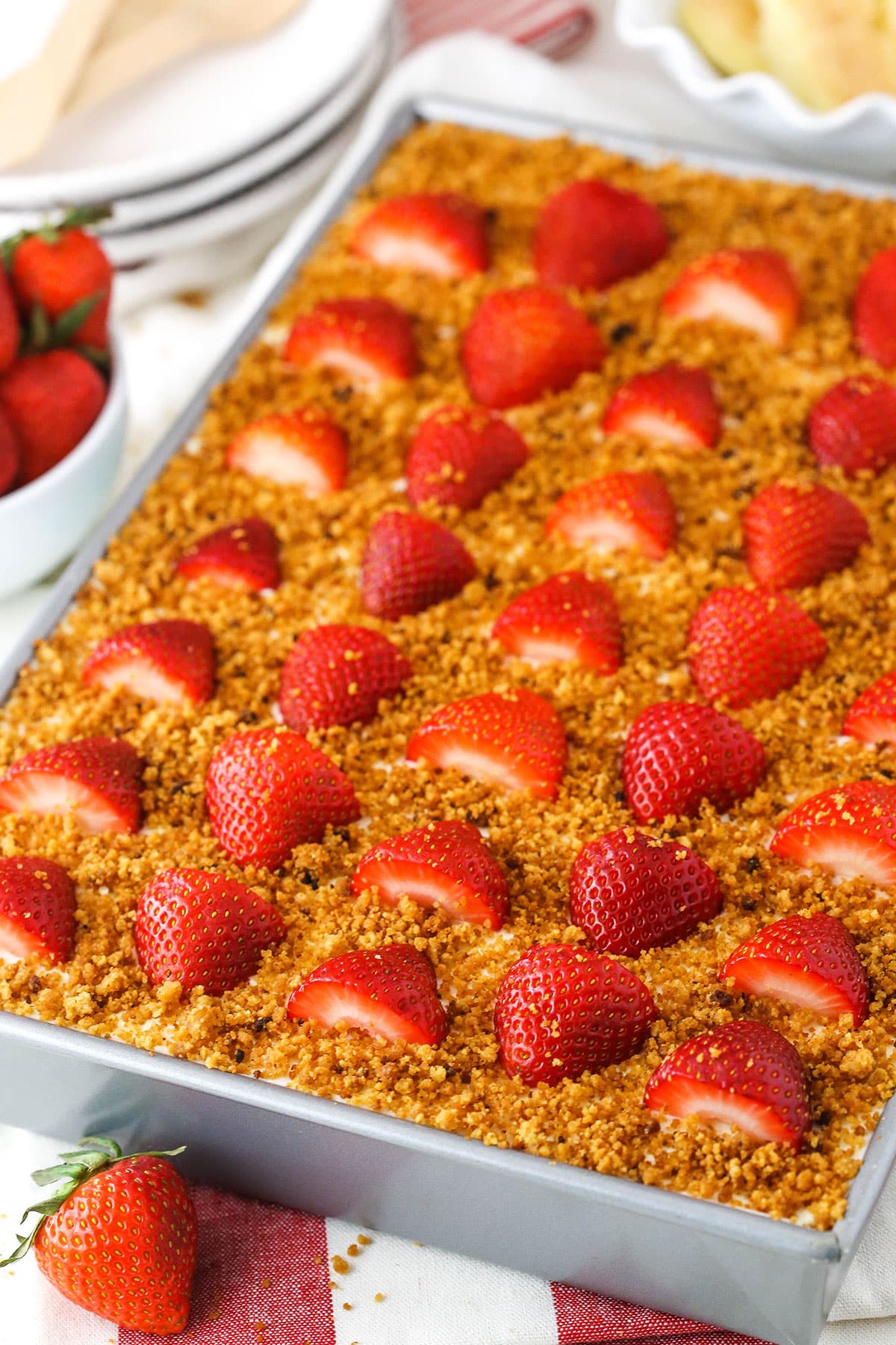 Strawberry Shortcake Icebox Cake in a metal pan topped with cut strawberries