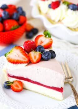 A slice of Berry Almond Cream Pie next to a fork on a white plate