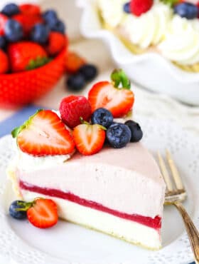 A slice of Berry Almond Cream Pie next to a fork on a white plate