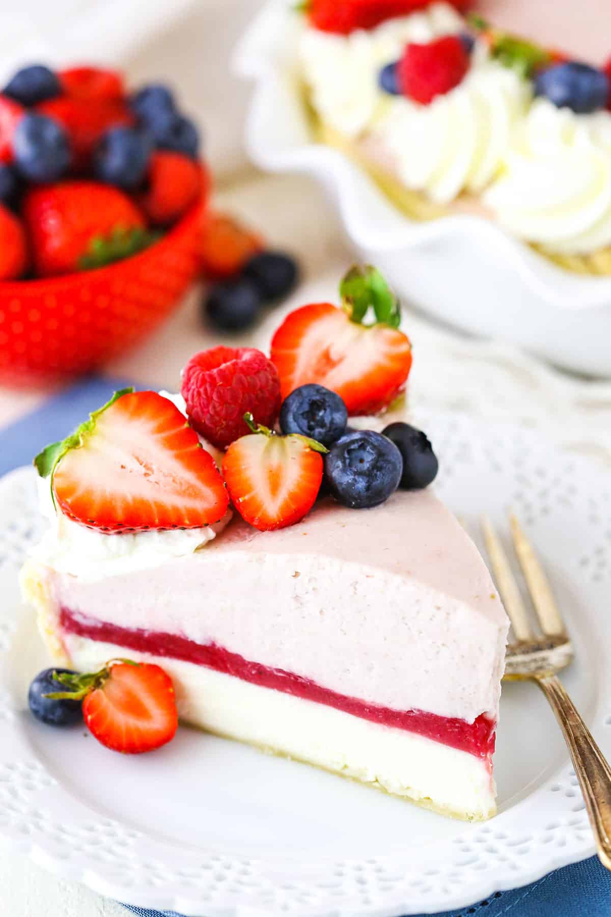 A slice of Berry Almond Cream Pie next to a fork on a white plate