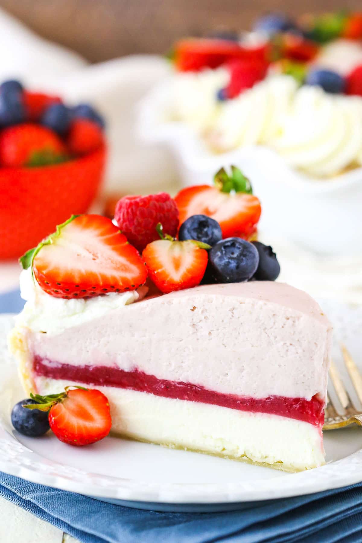 A slice of Berry Almond Cream Pie next to a fork on a white plate